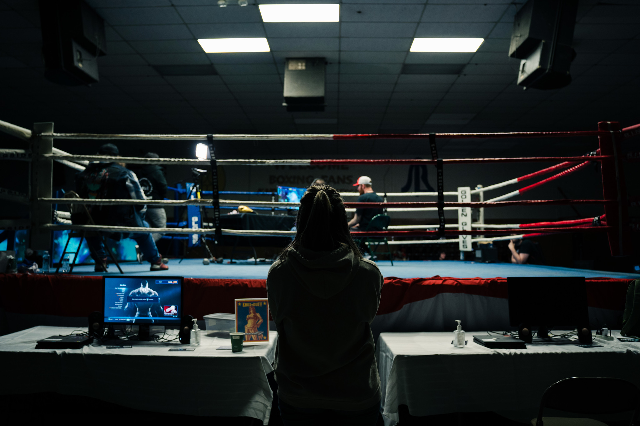 Fighting Game Player spectating outside of Boxing Ring.